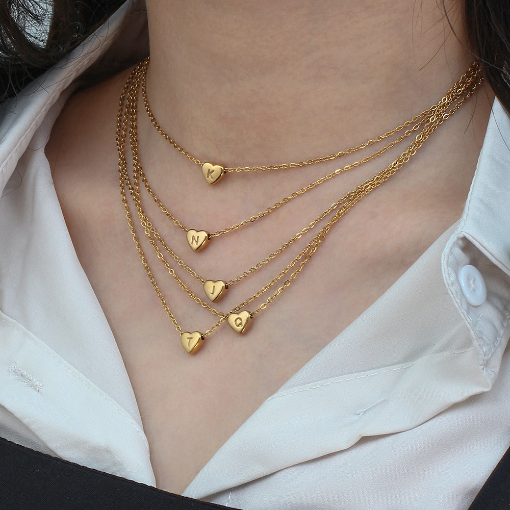 Gold heart pendant necklace with initial detail