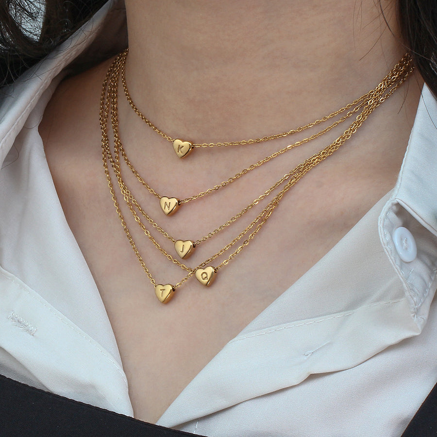 Gold heart pendant necklace with initial detail